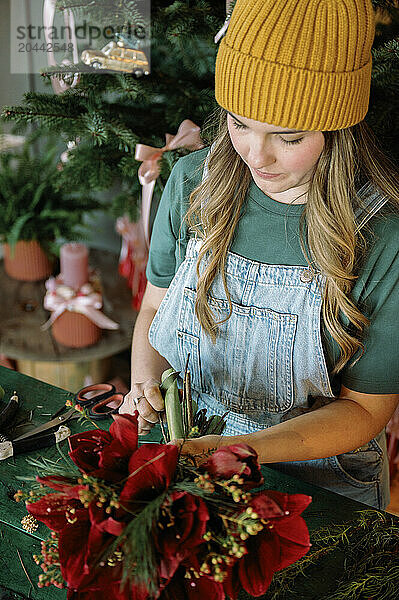 Young florist making bouquet in shop