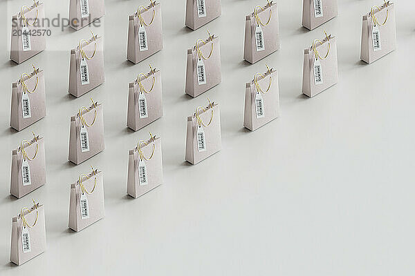 Minimalist shopping bags arranged in row against gray background