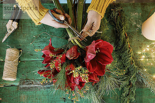 Florist cutting thread tied on bouquet in store