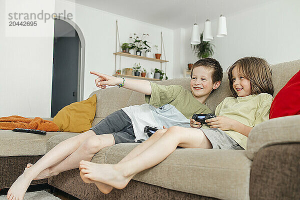 Happy boys playing video game at home