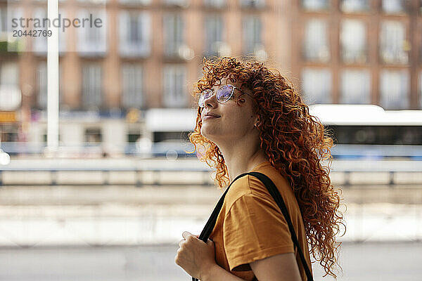 Smiling beautiful young redhead woman wearing eyeglasses