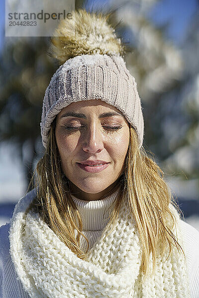 Serene woman with eyes closed in winter