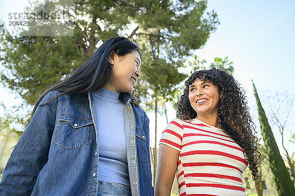 Smiling friends spending leisure time together on sunny day