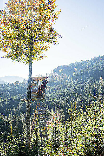 Senior man looking at forest from observation tower