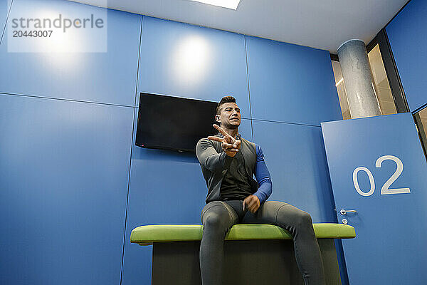 Instructor in sportswear gesturing at indoor skydiving center