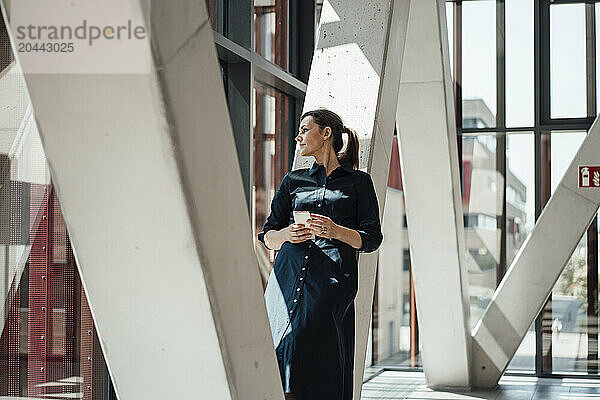 Businesswoman leaning on pillar at airport lobby