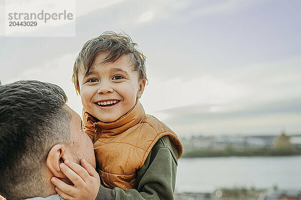 Cute boy spending leisure time with father at public park