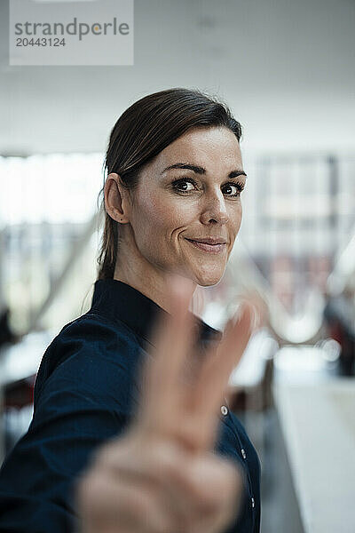 Happy businesswoman gesturing at airport lobby