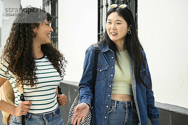 Young woman talking with friend at street