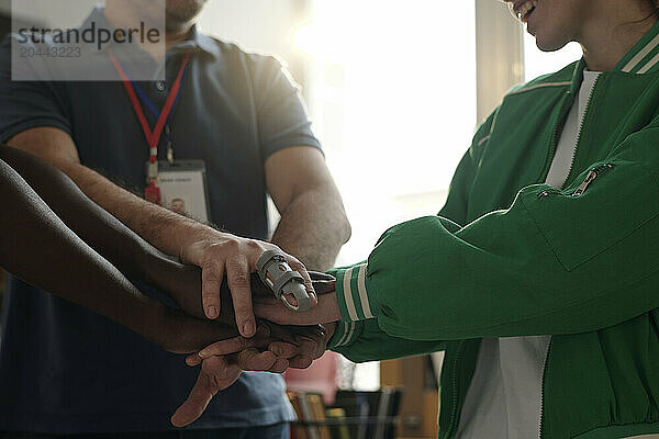 Coach and students staking hands and encouraging each other in unity