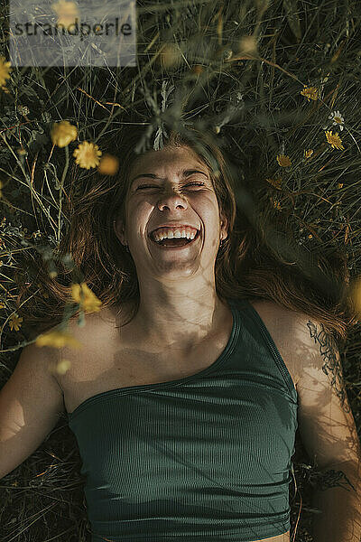 Cheerful woman lying on grass