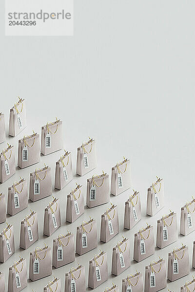 Shopping bags with labels kept in row over gray background