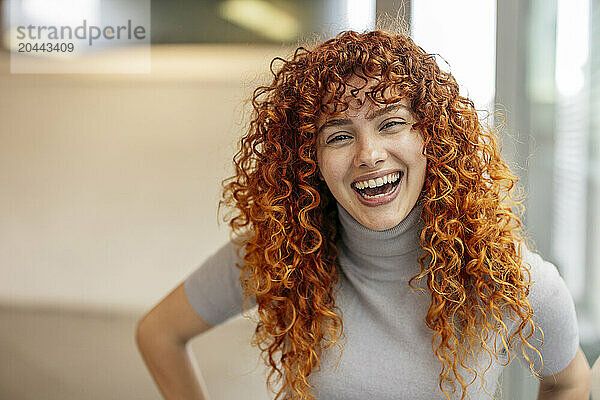 Happy redhead young woman with curly hair