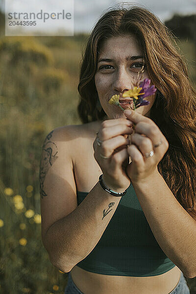 Young woman with flowers in meadow