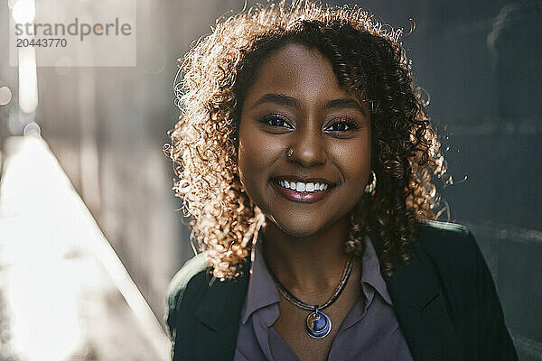 Smiling young beautiful businesswoman with curly hair