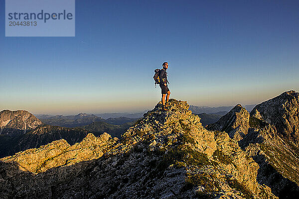 Young man standing on Steinfeldspitze rock at Altenmarkt  Zauchensee  Salzburg  Austria