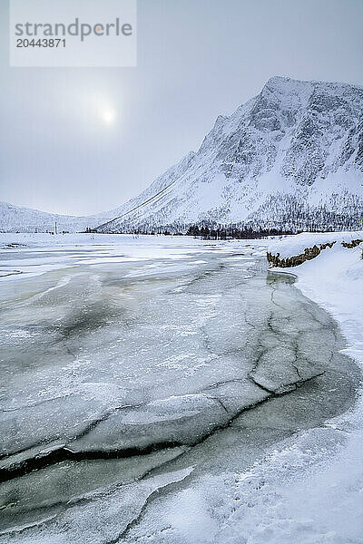 Frozen water stream of Ballesvika at sunrise in Senja island  Troms  Norway