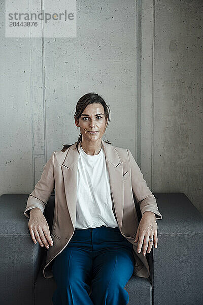 Businesswoman sitting on armchair at office