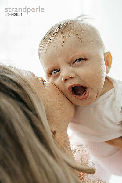 Mother kissing cute baby boy