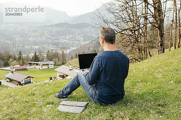 Freelancer using laptop on grass