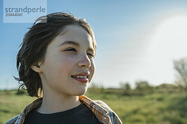 Smiling boy squinting on sunny day