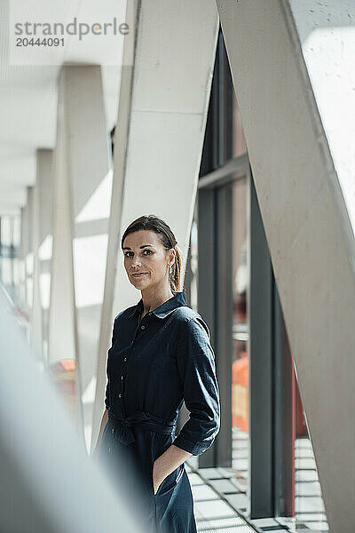 Businesswoman wearing black dress standing at airport lobby