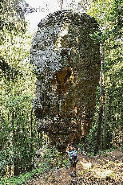 Senior man photographing rock at Eifel national park in Rhineland  Germany