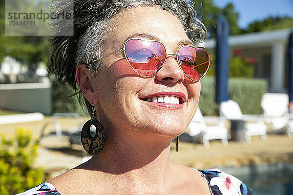 Happy mature woman wearing sunglasses on sunny day