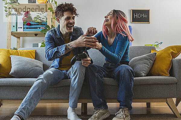 Cheerful friends enjoying and playing video game at home