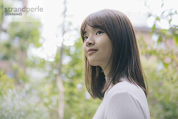 Smiling woman in front of trees at park