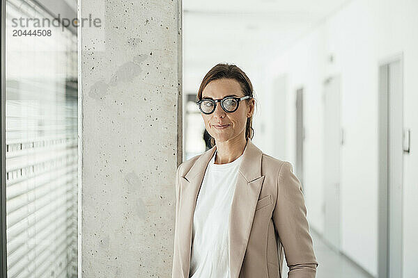 Businesswoman wearing eyeglasses standing at office