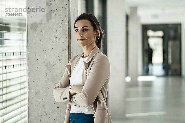 Businesswoman with arms crossed standing at office