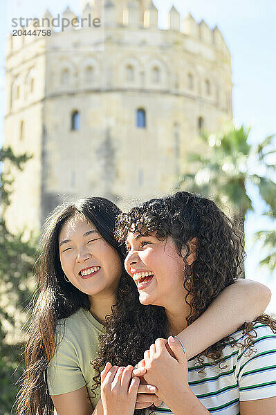 Playful friends enjoying in front of Torre del Oro