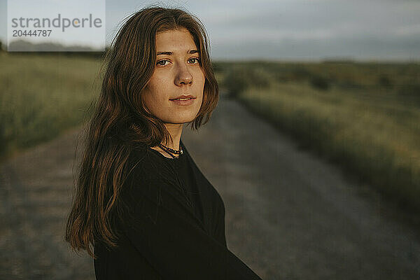 Young woman standing on road