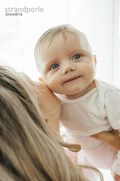 Mother kissing cute infant son