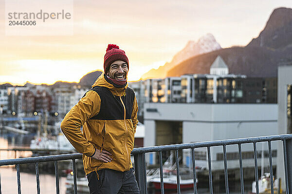 Happy tourist standing near houses at sunset  Svolvaer  Austvagoy  Lofoten  Nordland County  Norway