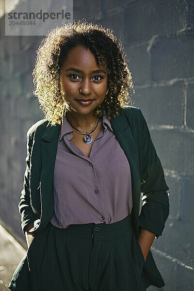 Portrait of young beautiful businesswoman with hands in pockets