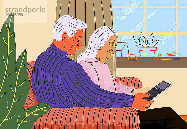 Elderly couple sharing tablet and sitting on sofa at home