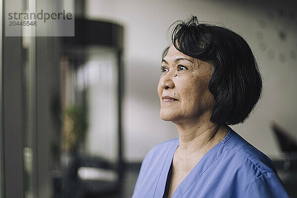 Thoughtful senior female physician with short hair at hospital