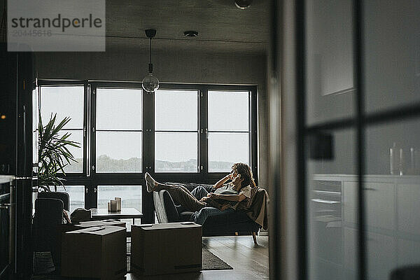 Thoughtful lesbian couple lying on sofa at home