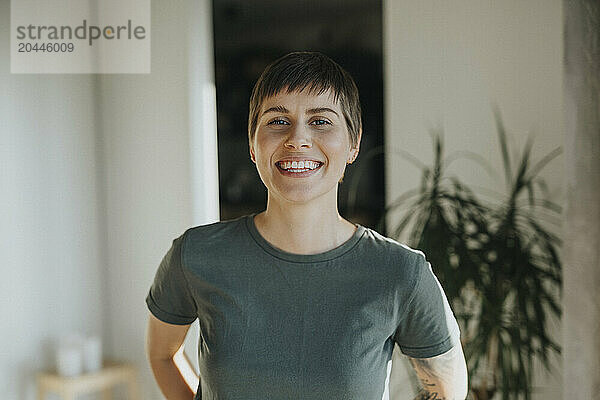 Portrait of happy woman with short hair at home