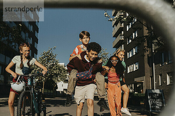 Group of playful friends walking on street