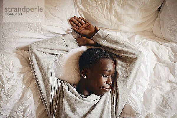 Directly above view of teenage boy sleeping on bed at home