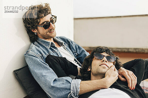 Young man lying down on boyfriend's lap on building rooftop