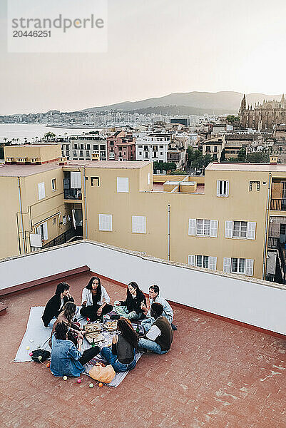 High angle view of male and female friends enjoying at rooftop party