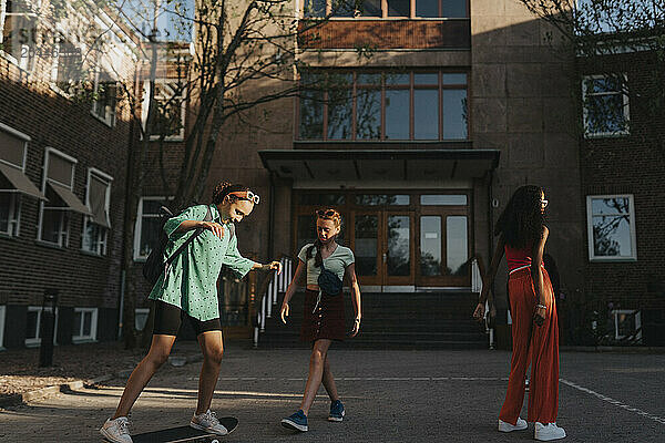 Girls spending leisure time while playing outside campus