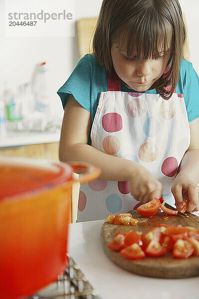 Young Girl Cutting Tomatoes