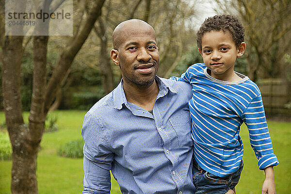 Father Holding Young Son Outdoors