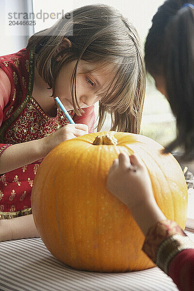 Young Girls Making a Pumpkin Lantern