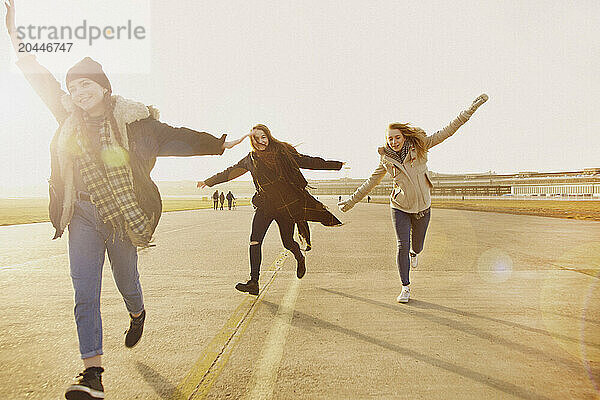 Teenage Girls Running with Arms Outstretched